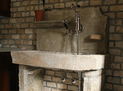 Antique reclaimed stone basin sink salvaged restored and installed in this traditional style Mediterranean home.